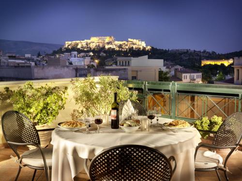 a table with plates of food and a bottle of wine at Jason Inn in Athens