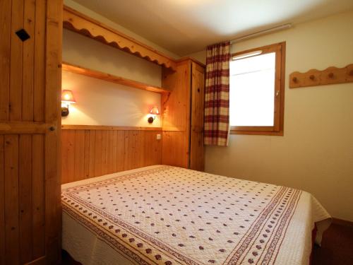 a bedroom with a bed and a window at Appartement Lanslebourg-Mont-Cenis, 2 pièces, 4 personnes - FR-1-508-181 in Lanslebourg-Mont-Cenis