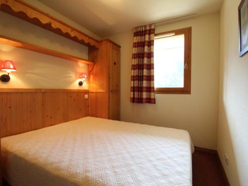 a bedroom with a bed and a window at Appartement Lanslebourg-Mont-Cenis, 2 pièces, 4 personnes - FR-1-508-143 in Lanslebourg-Mont-Cenis