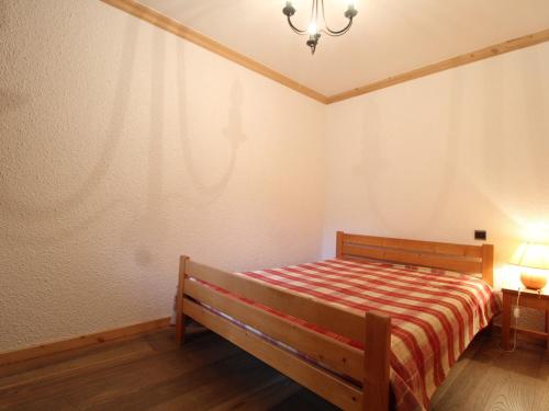 a small bedroom with a bed and a lamp at Appartement Lanslevillard, 2 pièces, 5 personnes - FR-1-508-144 in Lanslevillard