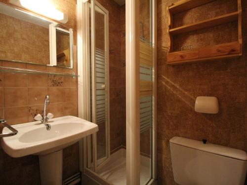 uma casa de banho com um lavatório, um chuveiro e um WC. em Appartement Lanslevillard, 2 pièces, 4 personnes - FR-1-508-209 em Lanslevillard