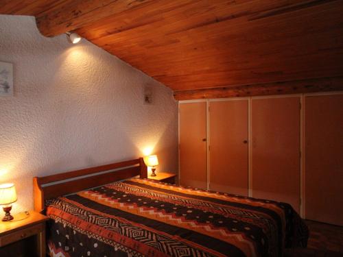 1 dormitorio con 1 cama con 2 lámparas y armarios en Appartement Aussois, 2 pièces, 4 personnes - FR-1-508-157, en Aussois