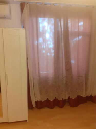 a window with a curtain in a room at Happy central Bucharest acomodation in Bucharest