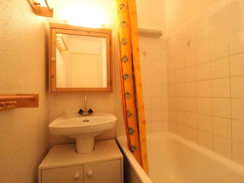 a bathroom with a sink and a mirror and a tub at Studio Lanslevillard, 1 pièce, 4 personnes - FR-1-508-194 in Lanslevillard