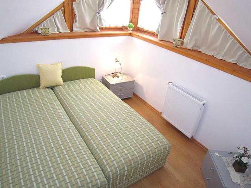 um pequeno quarto com uma cama e uma janela em Nádas Társasház em Balatonlelle