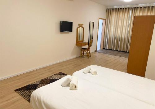 a room with two beds and a tv on the wall at Grand Hotel Bethlehem in Bethlehem
