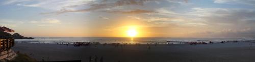 a group of people on the beach at sunset at Costa Dourada Pousada in Arraial do Cabo