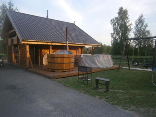 a large wooden cabin with a gazebo at Viesu namiņš Dālderi in Varakļāni