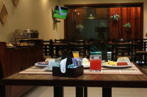 a table with plates of food and drinks on it at Costa Dourada Pousada in Arraial do Cabo
