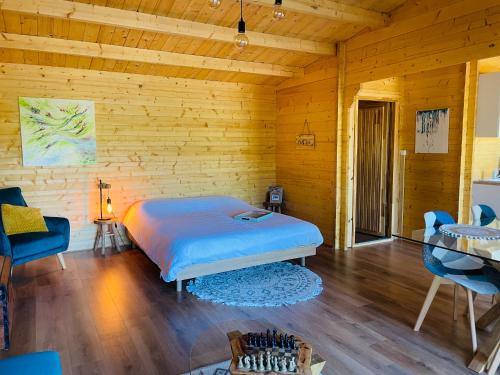 1 dormitorio con 1 cama y pared de madera en Chalet Loda cosy spa privé en Roussayrolles