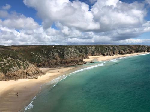 an aerial view of a beach with people in the water at Archavon Luxury Studio in St Just