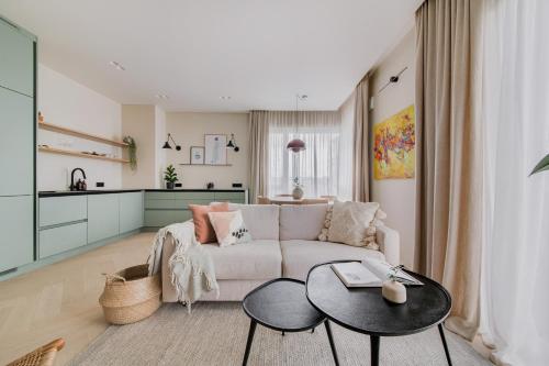een woonkamer met een bank en een tafel bij #stayhere - Brand New Unique Designer 1BDR in Trendy Neighbourhood in Vilnius