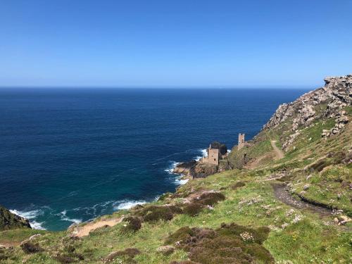 a castle on a hill next to the ocean at Archavon Luxury Studio in St Just
