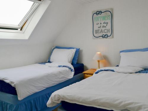 a room with two beds and a sign on the wall at Beul-an-latha in Saint Abbs