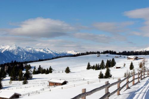 a snow covered mountain with houses and a fence at Hotel Rosenheim in Rodengo