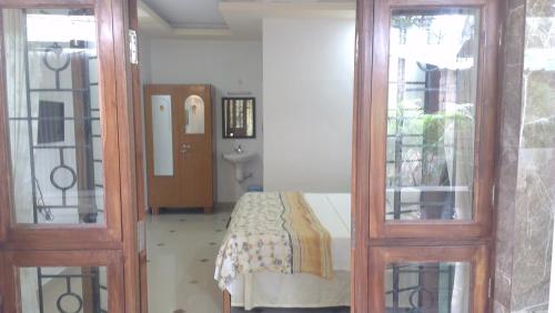 a bedroom with a bed and two glass doors at Alba Rooms Palolem Rosebuds in Palolem