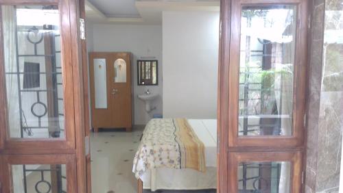 ein Schlafzimmer mit einem Bett und zwei Glastüren in der Unterkunft Alba Rooms Palolem Rosebuds in Palolem