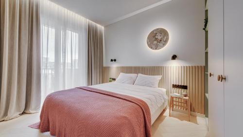 een slaapkamer met een bed en een groot raam bij #stayhere - Brand New Unique Designer 1BDR in Trendy Neighbourhood in Vilnius