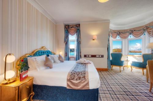 a hotel room with a large bed and windows at Muthu Alexandra Hotel in Oban
