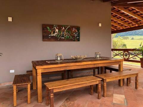 a wooden table and benches in a room at Pousada Villa Paraizo in Ribeirão Claro