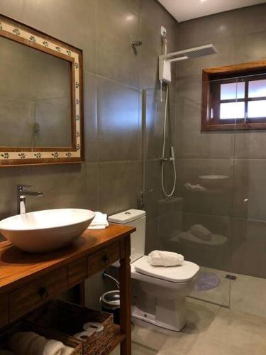 a bathroom with a sink and a toilet and a shower at Pousada Villa Paraizo in Ribeirão Claro