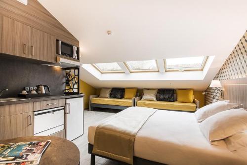 サン・ラファエルにあるUnique Hôtel & Spaのベッドルーム1室(ベッド1台付)、天窓付きのキッチンが備わります。
