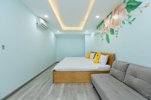 um pequeno quarto com uma cama e um sofá em Vung Tau Gold Sea Apartment Cookies Homestay (Căn Hộ Biển) em Vung Tau