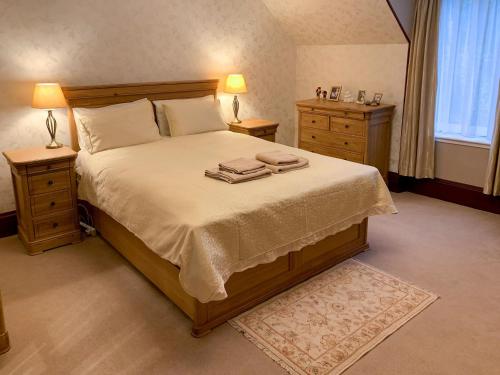 a bedroom with a large bed with two night stands at The Coyles - Uk31466 in Ballater