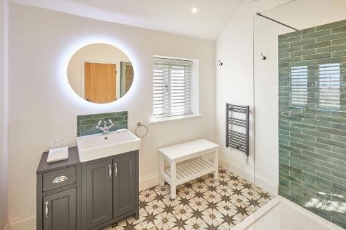 a bathroom with a sink and a shower with a mirror at The Irishman's Cottage in Yedingham