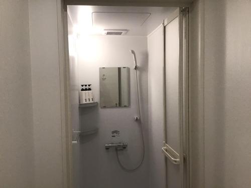 y baño con ducha y luz. en ゲストハウス長岡街宿 en Nagaoka