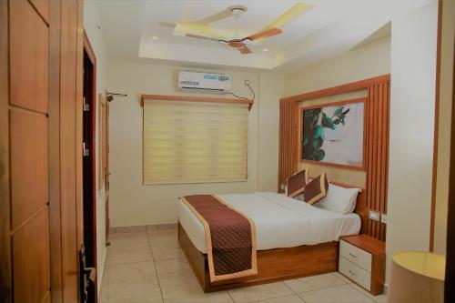 a small bedroom with a bed and a window at AGS Residency in Ernakulam