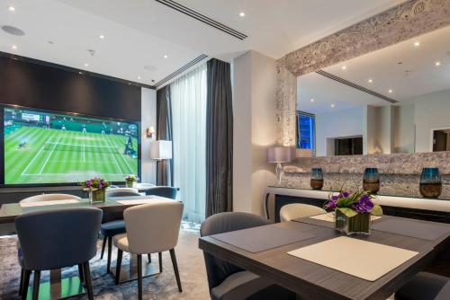 ein Esszimmer mit Tischen und ein Tennisspiel an der Wand in der Unterkunft Eccleston Square Hotel in London