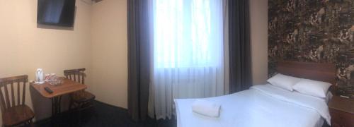 a bedroom with a bed and a table and a window at Hotel LaMa 2 in Kyiv