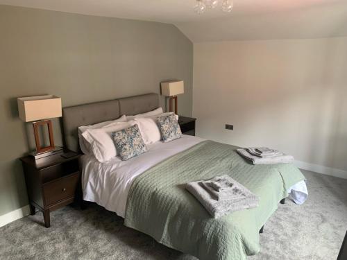 a bedroom with a bed with a green blanket and pillows at RECENTLY RENOVATED property in the heart of Southwell in Southwell