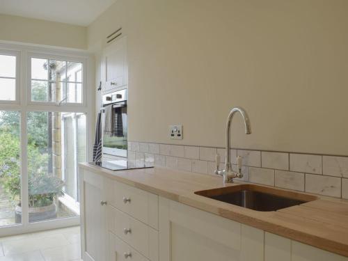a kitchen with a sink and a large window at Studio Quercus in Todenham