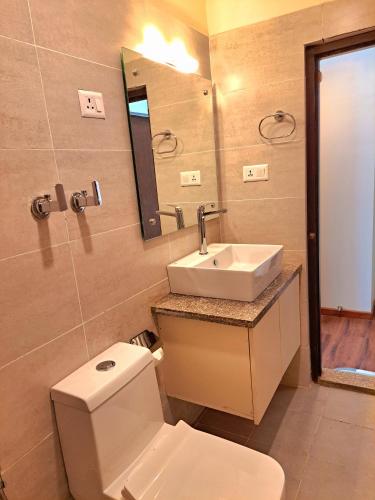 a bathroom with a toilet and a sink and a mirror at Rodeos Inn in Kathmandu