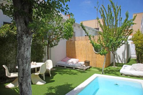 un patio trasero con una piscina, una mesa y un árbol en Villa Alba, en Barcelona
