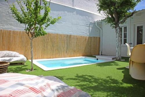 a backyard with a swimming pool in the grass at Fridays Flats Villa Alba in Barcelona
