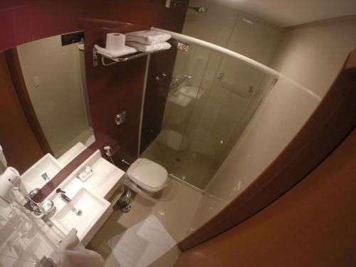 a bathroom with a glass shower and a toilet at Atlântico Golden Apart Hotel in Santos