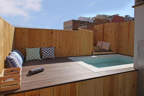 a hot tub on a deck with a wooden fence at Fridays Flats Casa Lemonade in Hospitalet de Llobregat