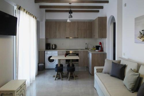 a living room and kitchen with a couch and a table at Skopelitis Village in Katapola