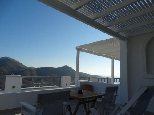 a patio with a table and chairs on a balcony at Skopelitis Village in Katapola