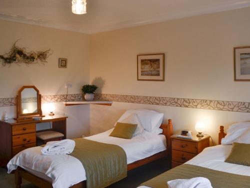 a hotel room with two beds and a mirror at West Tannacrieff in Stewarton