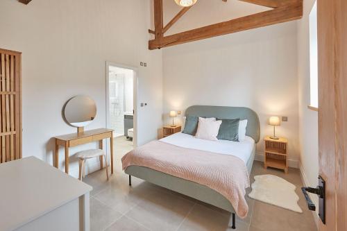 a bedroom with a bed and a table and a mirror at Orchard View Cottage in Yedingham