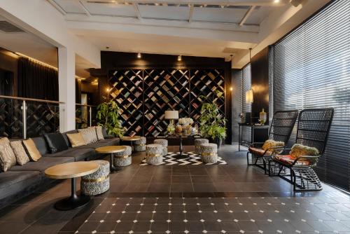 a living room with a couch and tables and chairs at Brown Beach House Tel-Aviv, a member of Brown Hotels in Tel Aviv