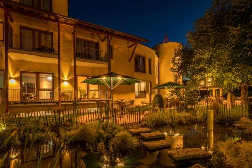 a hotel with a pond in front of a building at Mosers Blume Relax & Genuss Hotel in Haslach im Kinzigtal