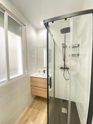 La salle de bains est pourvue d'une douche en verre et d'un lavabo. dans l'établissement Piso Lacy Ile, à Madrid