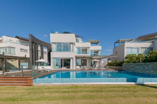 a villa with a swimming pool in front of a building at Vivo Mare Beachfront-Seaview Villas in Ayia Napa
