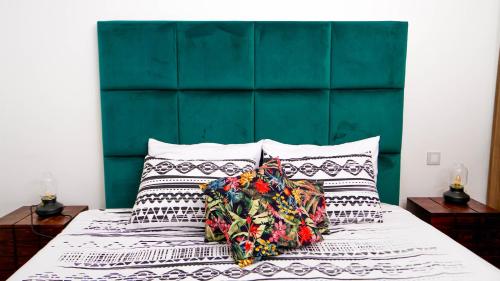 un letto con testiera verde e cuscini sopra di Sea View B16 - Mosqué Hassan II - By TheCasaEdition a Casablanca