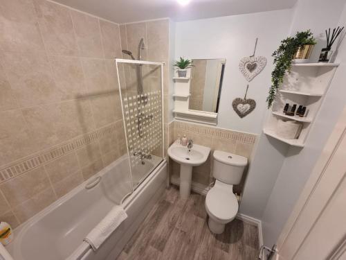 La salle de bains est pourvue de toilettes, d'un lavabo et d'une baignoire. dans l'établissement Caspian House (4 Bedrooms), à Grimsby